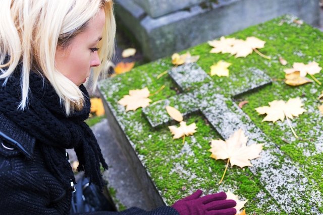 Solitary woman visiting relatives grave. woman grieving at a grave needing support